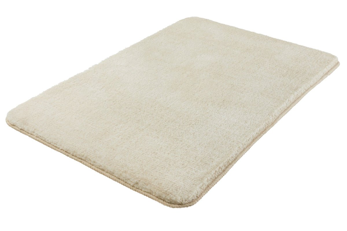 Rechteckige, flauschige Badematte in Beige auf weißem Hintergrund