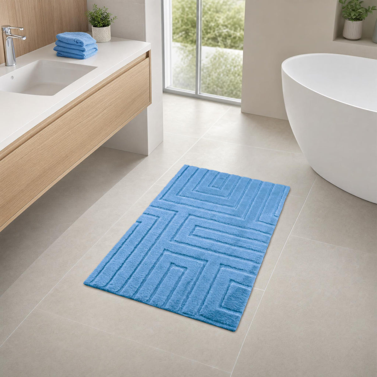 Blauer Badteppich in modernem Badezimmer mit Wanne und Waschtisch.