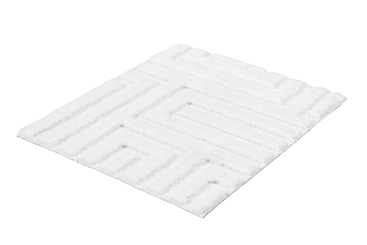Weißer, flauschiger Teppich mit geometrischem Muster auf hellem Grund.
