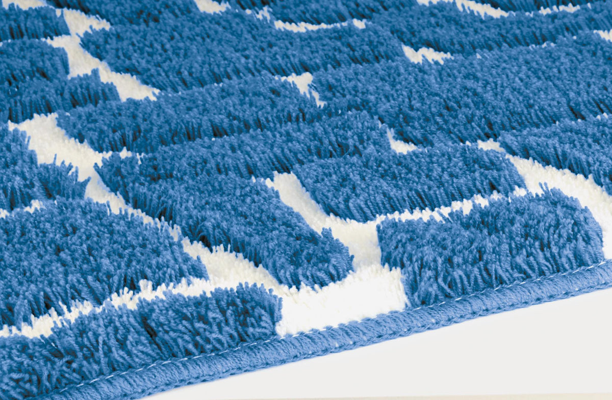 Blau-weißer Badteppich mit weichem Zickzackmuster in Nahaufnahme.