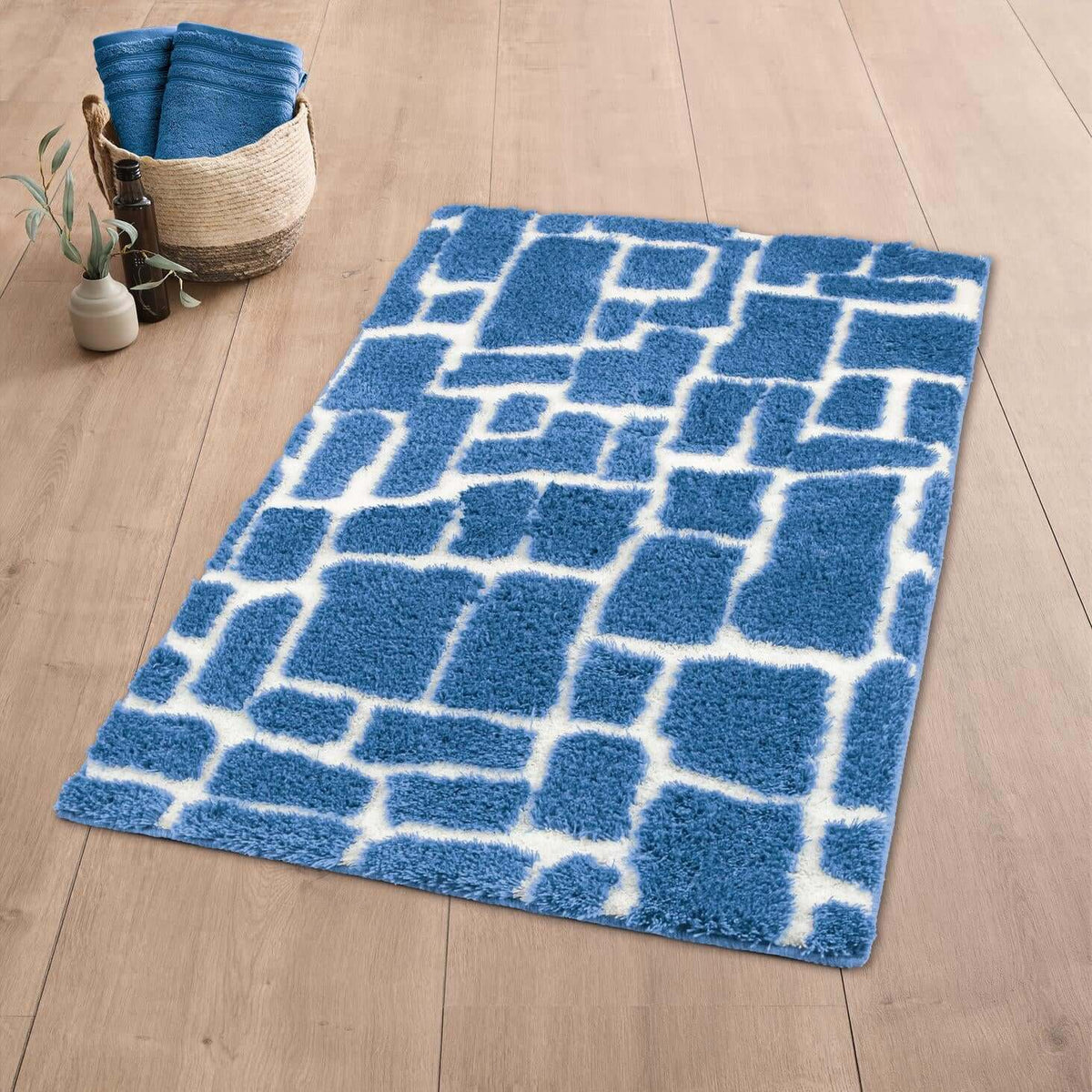Blauer Badteppich mit weißem Muster auf Holzoptikboden.