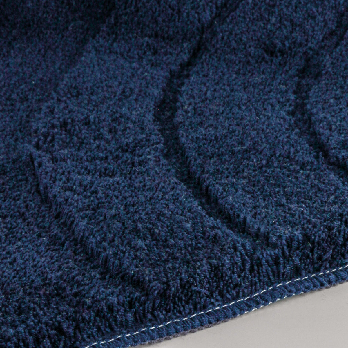 Dunkelblaue Badematte aus Frottier mit eingewebtem Wellenmuster Design
