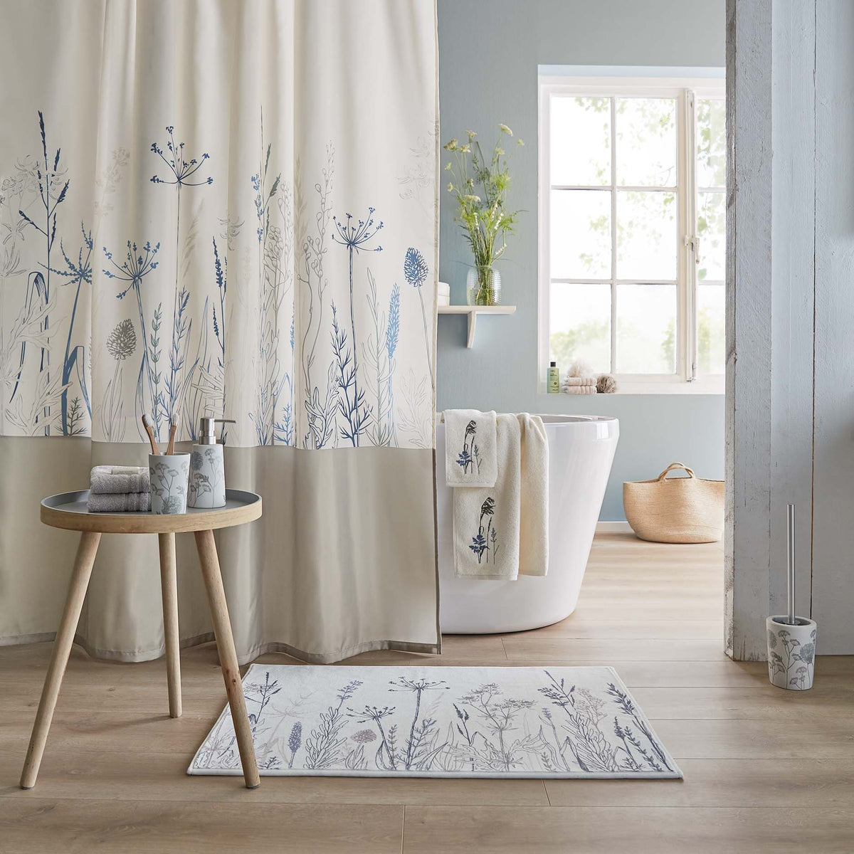 Helles Badezimmer mit Wanne, Duschvorhang und Textilien mit Pflanzenmotiv