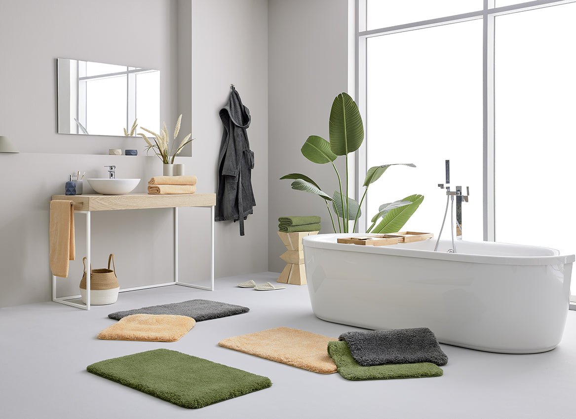 Modernes Badezimmer mit freistehender Wanne und bunten Badematten