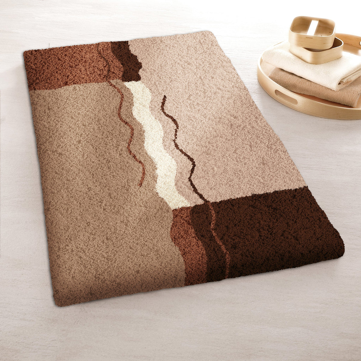 Badematte in Beige- und Brauntönen mit abstraktem Wellenmuster im Bad