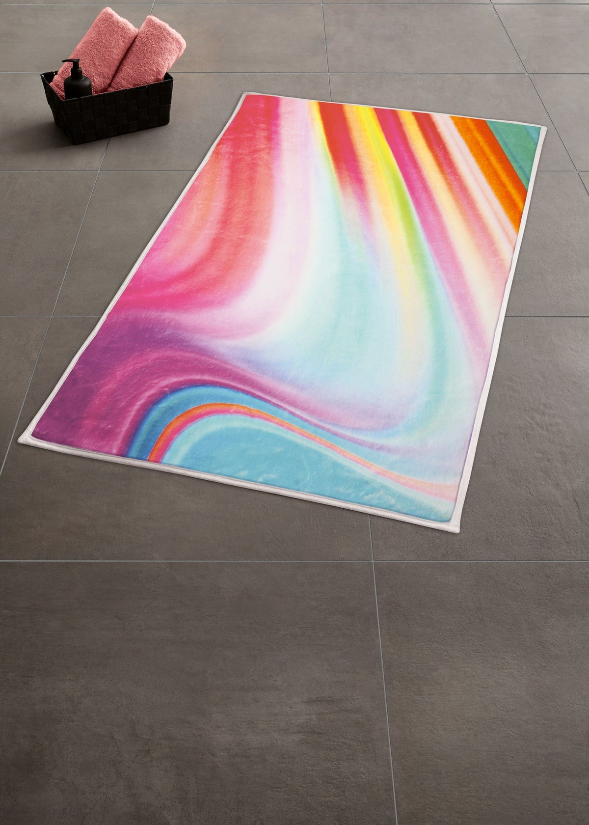 Buntes Strandtuch in Regenbogenfarben auf grauem Badezimmerboden