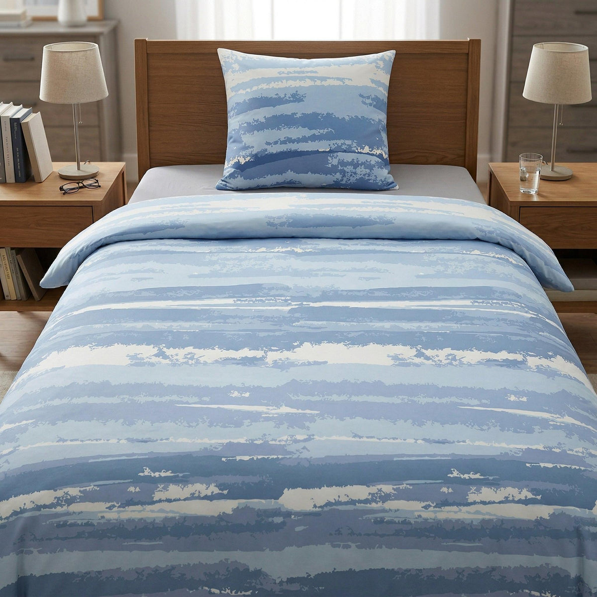 Blau-weiße Bettwäsche mit Streifenmuster auf gemachtem Bett.