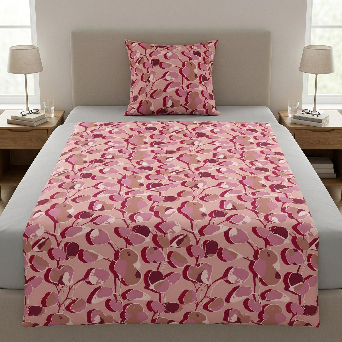 Rosa Bettwäsche mit abstraktem Blütenmuster auf einem Bett.