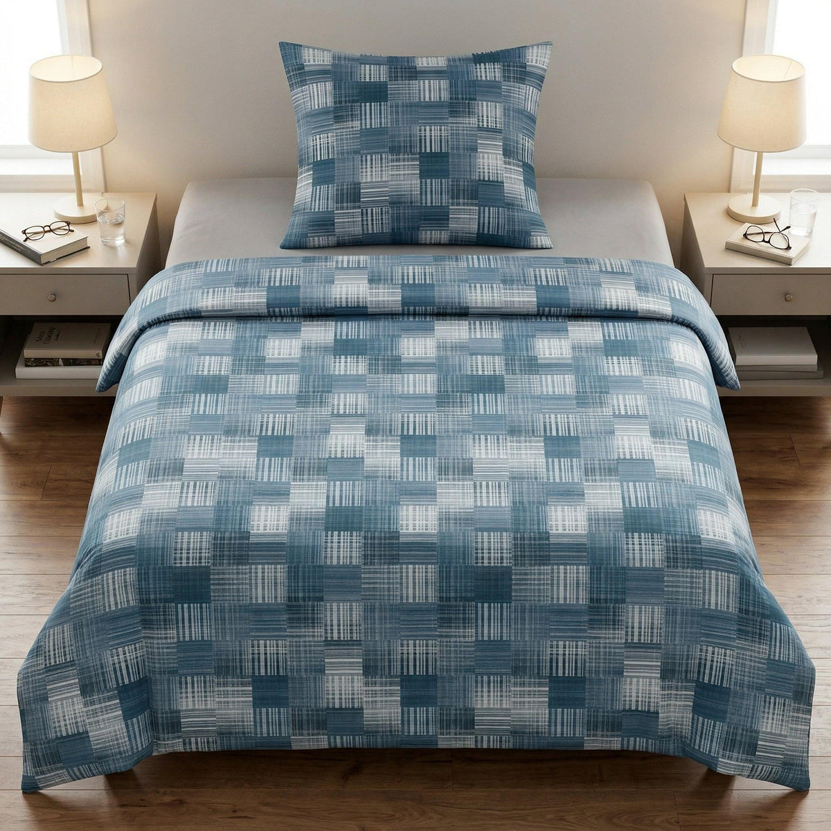 Blaue Bettwäsche mit geometrischem Muster auf modernem Bett.
