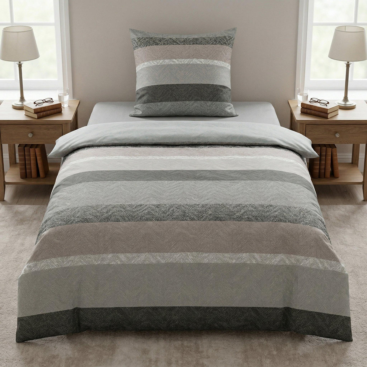 Gestreifte Bettwäsche in Grau und Beige auf modernem Bett.