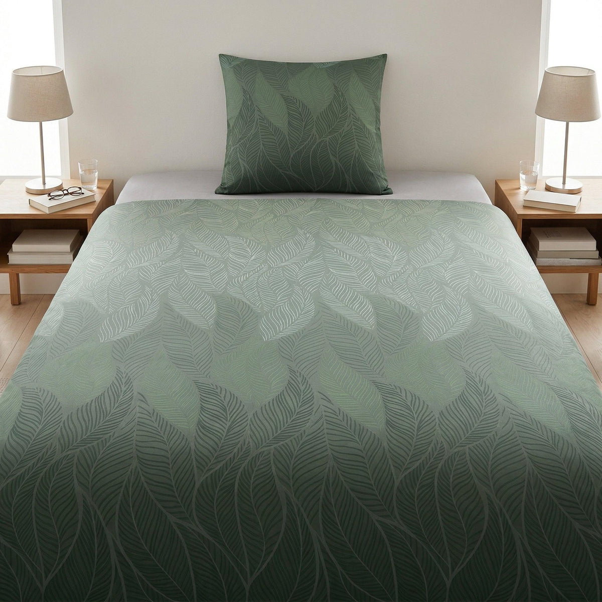 Grün gemusterte Bettwäsche mit Blättermotiv auf modernem Bett.