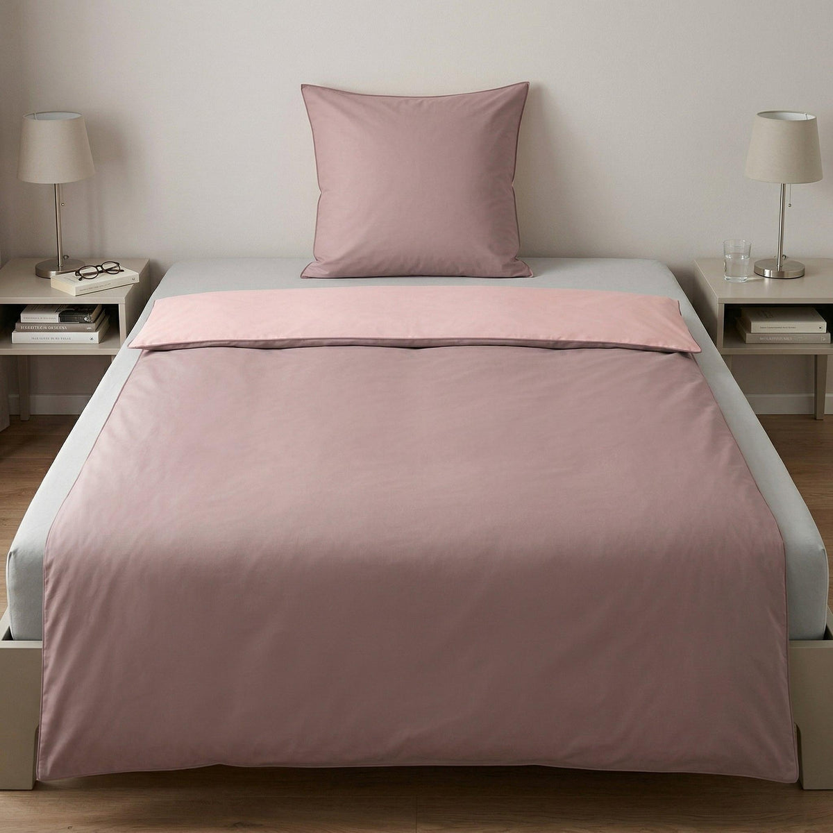 Rosa Bettwäsche-Set auf gemachtem Bett mit Kissen.