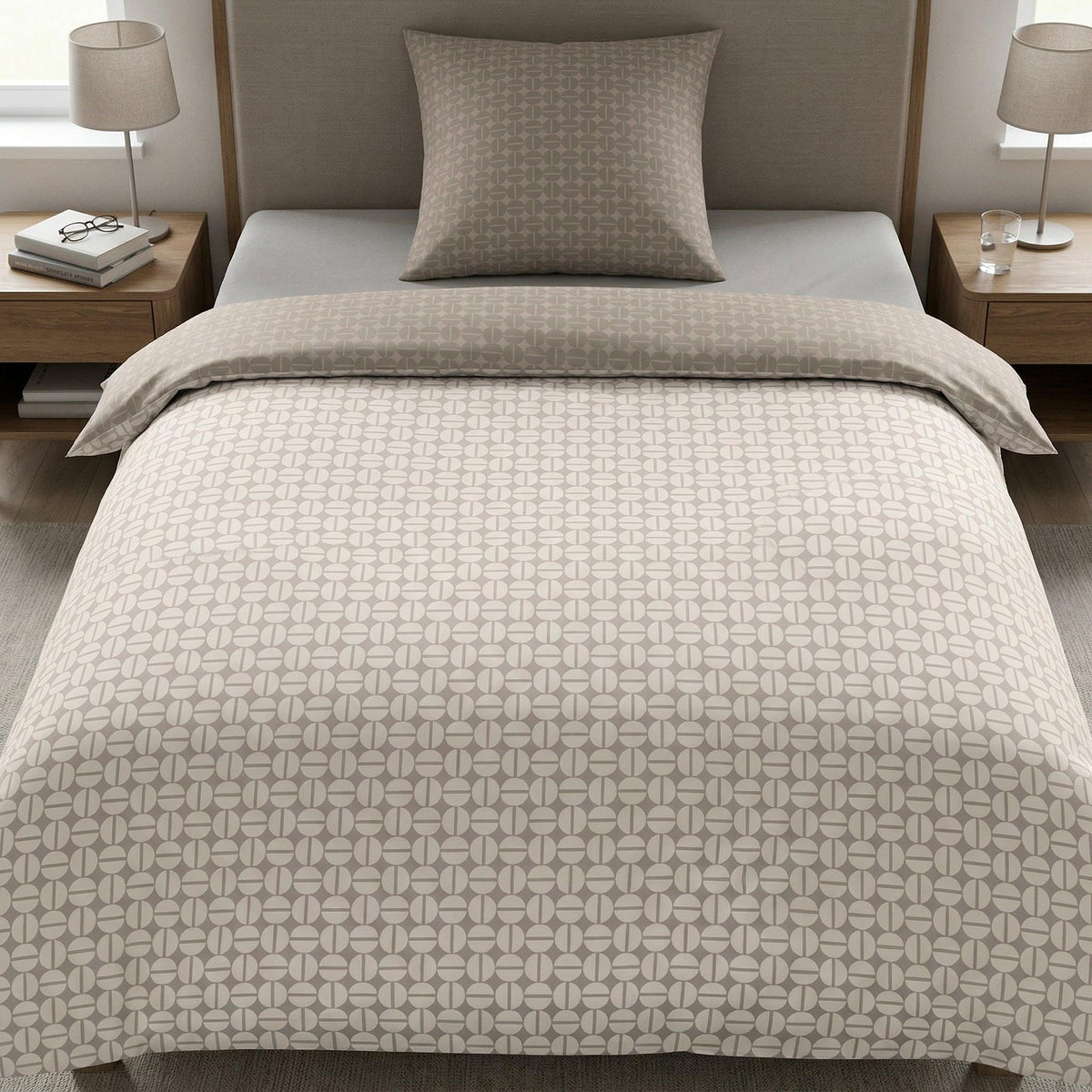 Beige Bettwäsche mit grafischem Muster auf modernem Bett.