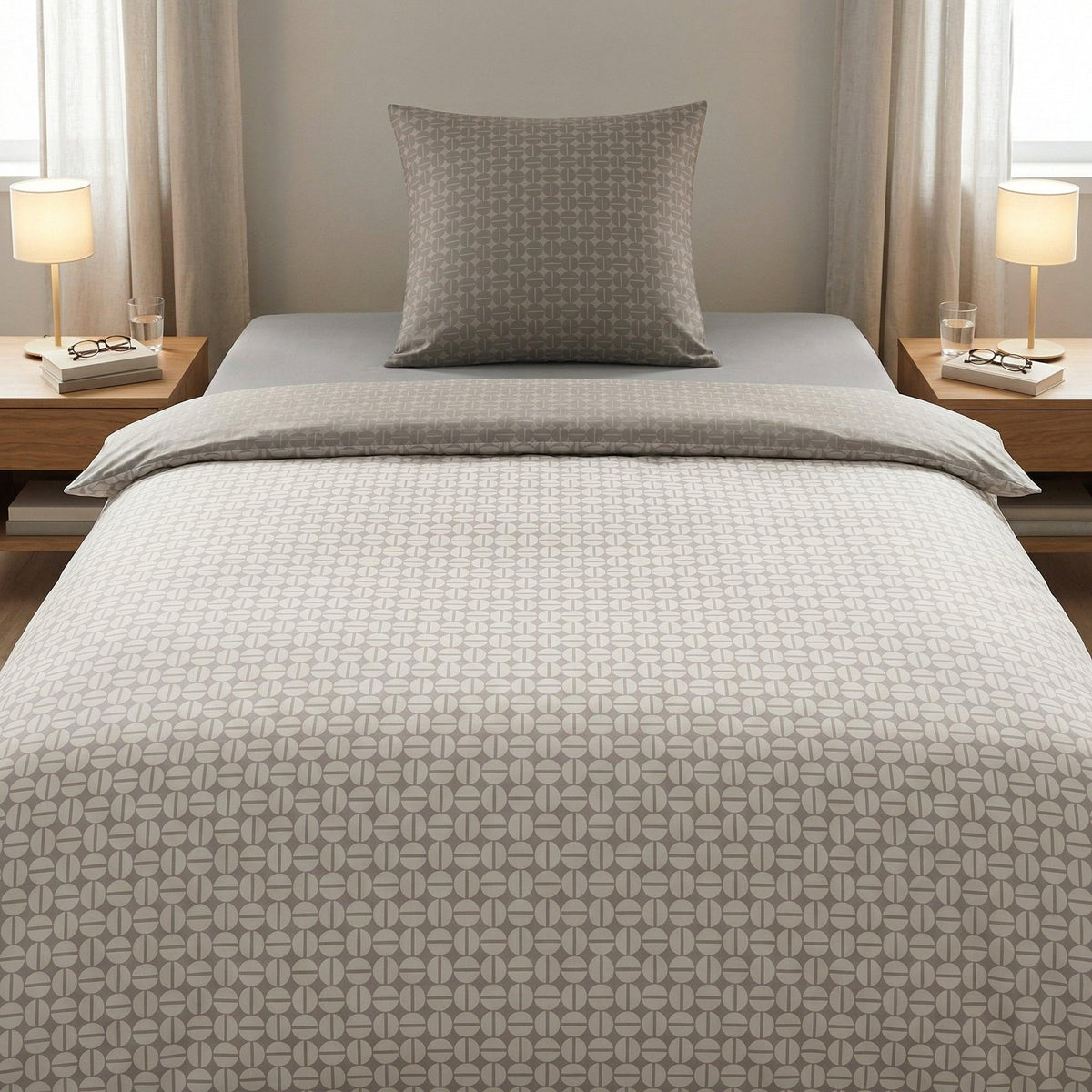 Graue Bettwäsche mit grafischem Muster auf einem modernem Bett.