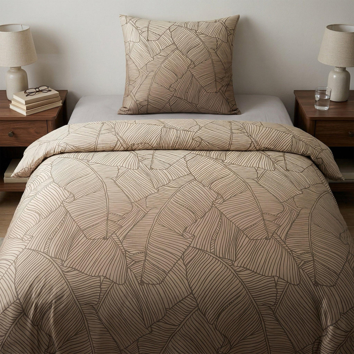 Beige Bettwäsche mit Blättermuster auf modern gemachtem Bett.