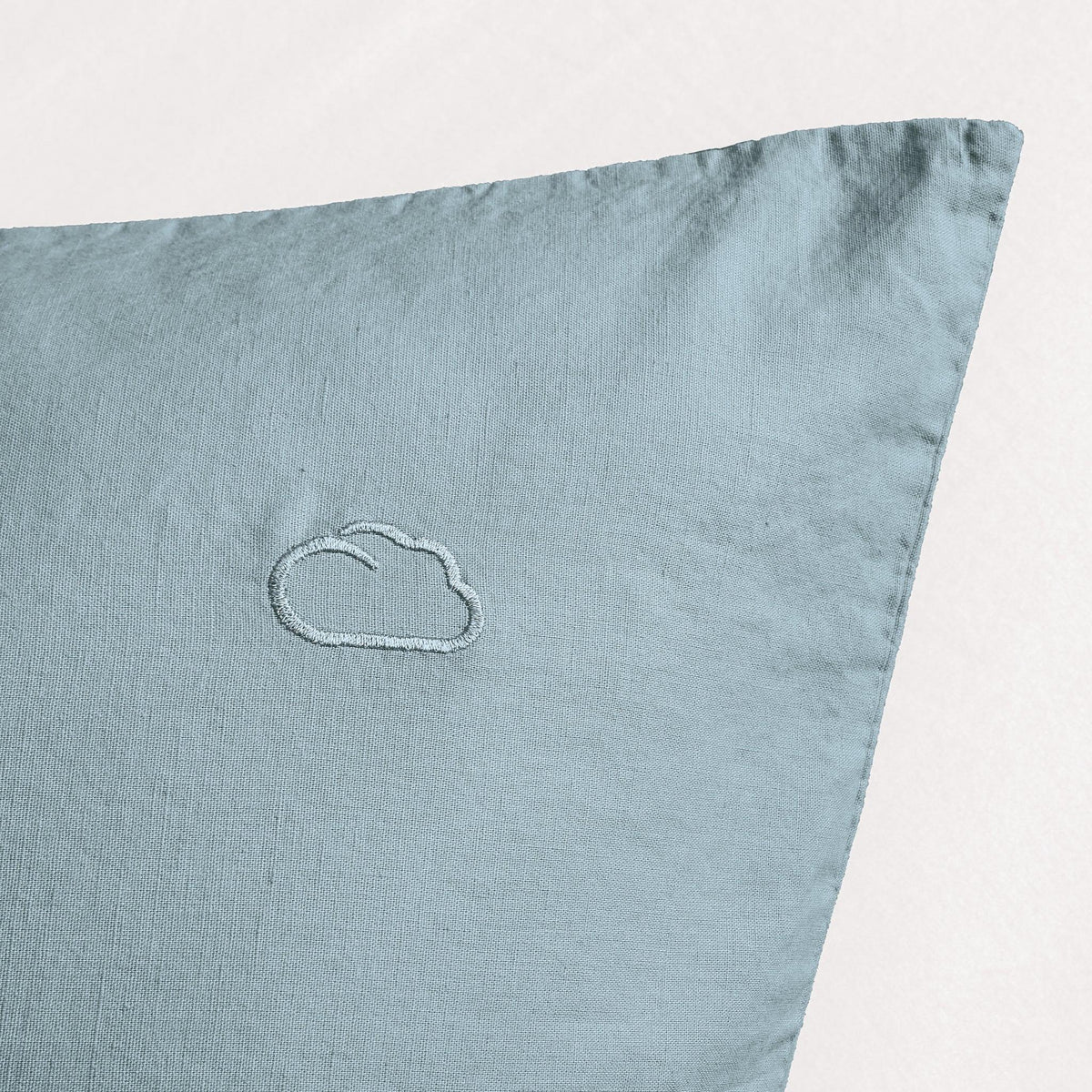 Hellblauer Kissenbezug aus Leinen mit kleiner, dezenter Wolken-Stickerei