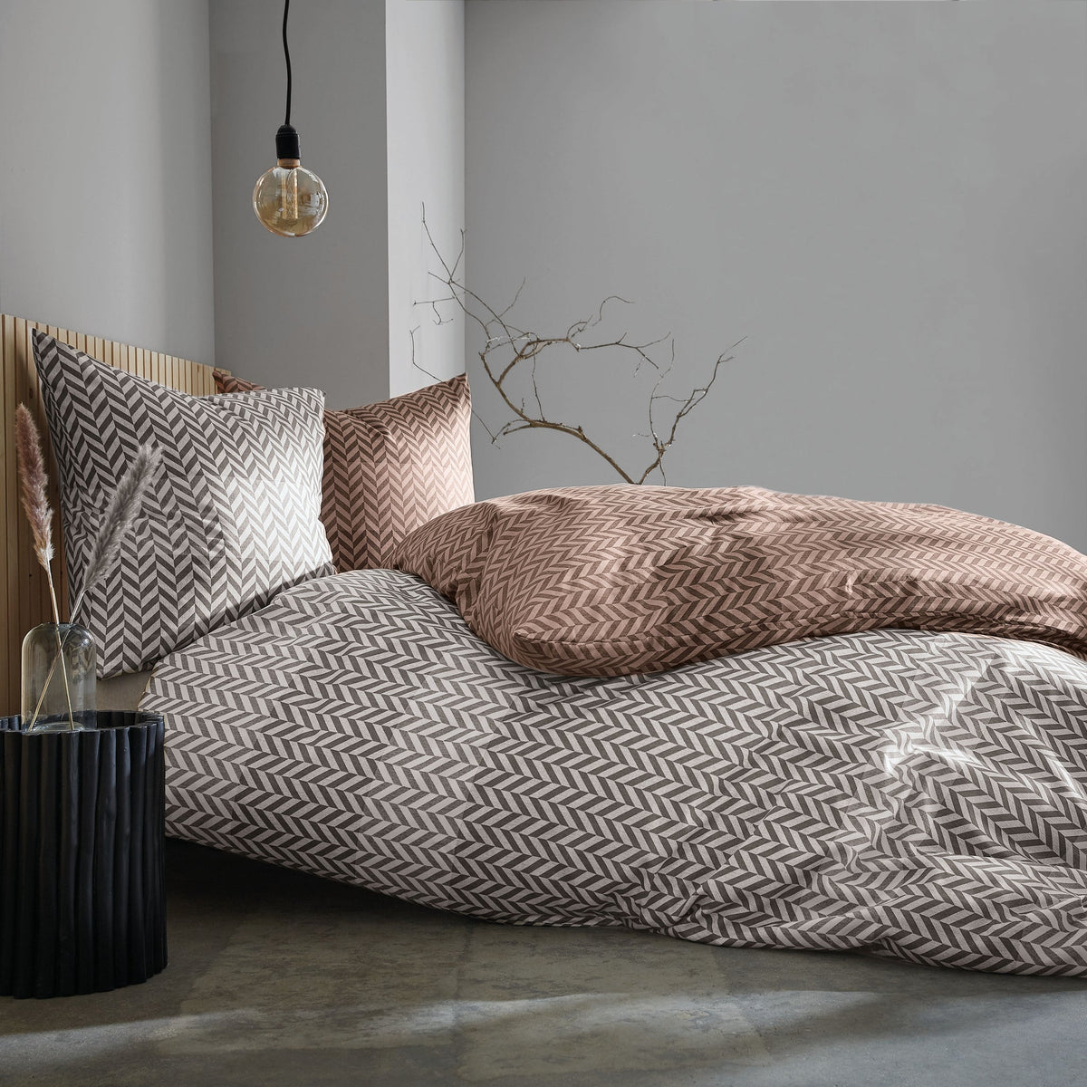 Modernes Bett mit gemusterter Beige-Grau-Bettwäsche, Lampe daneben