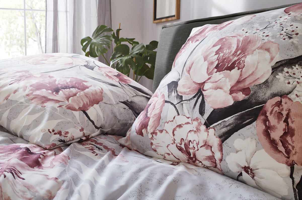 Bettwäsche mit großflächigem rosa Blumenmuster auf Kissen und Decke