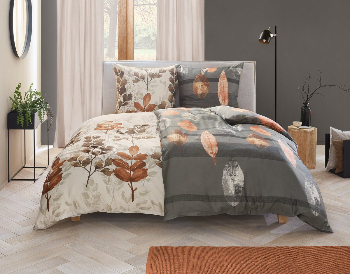 Doppelbett mit grauer Bettwäsche und Blattmotiv in Braun und Beige