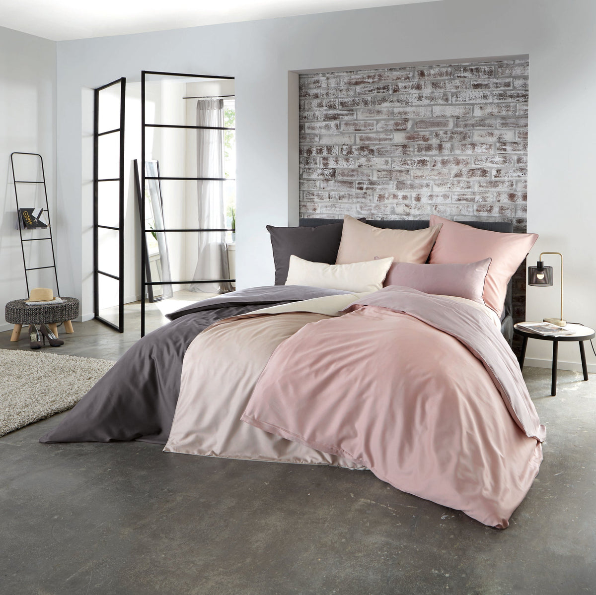 Modernes Schlafzimmer mit rosa und grauer Bettwäsche auf Doppelbett