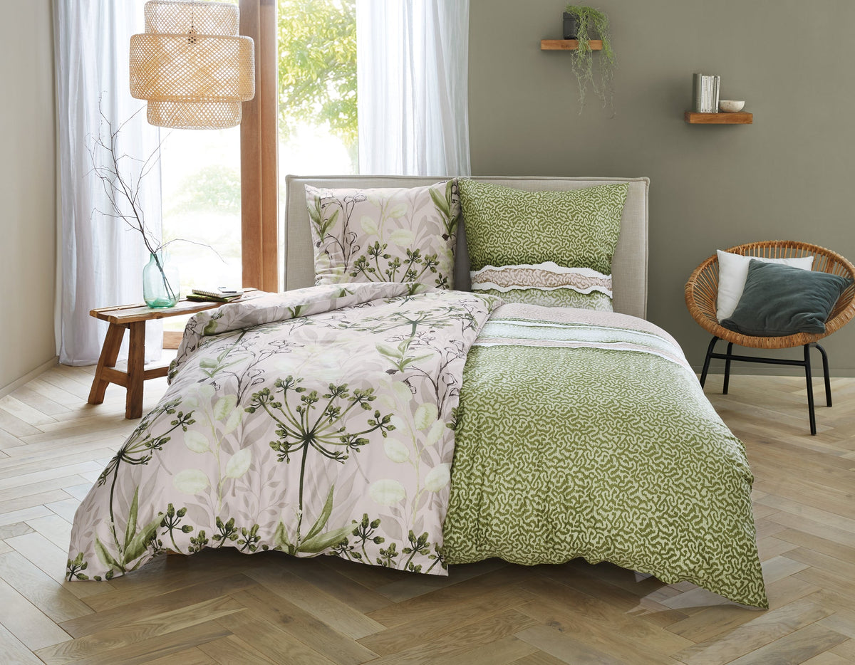 Doppelbett mit grün geblümter und beigefarbener Bettwäsche im Zimmer