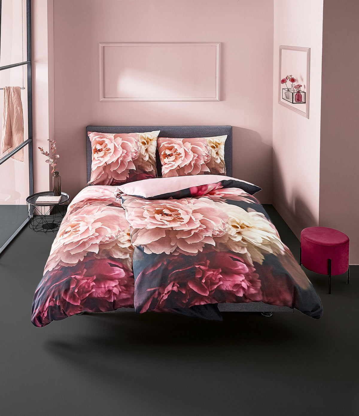Doppelbett mit floraler Bettwäsche in rosa und dunklen Rottönen gehalten