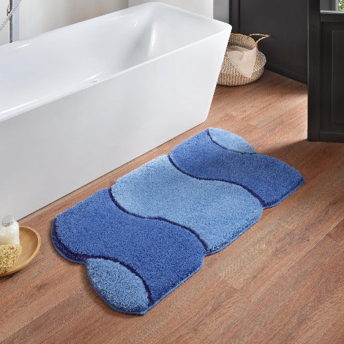 Blauer Badematte mit Wellenmuster vor weißer freistehender Badewanne