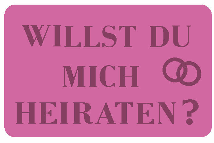Rosa Schild mit Aufschrift Willst du mich heiraten und zwei Ringen