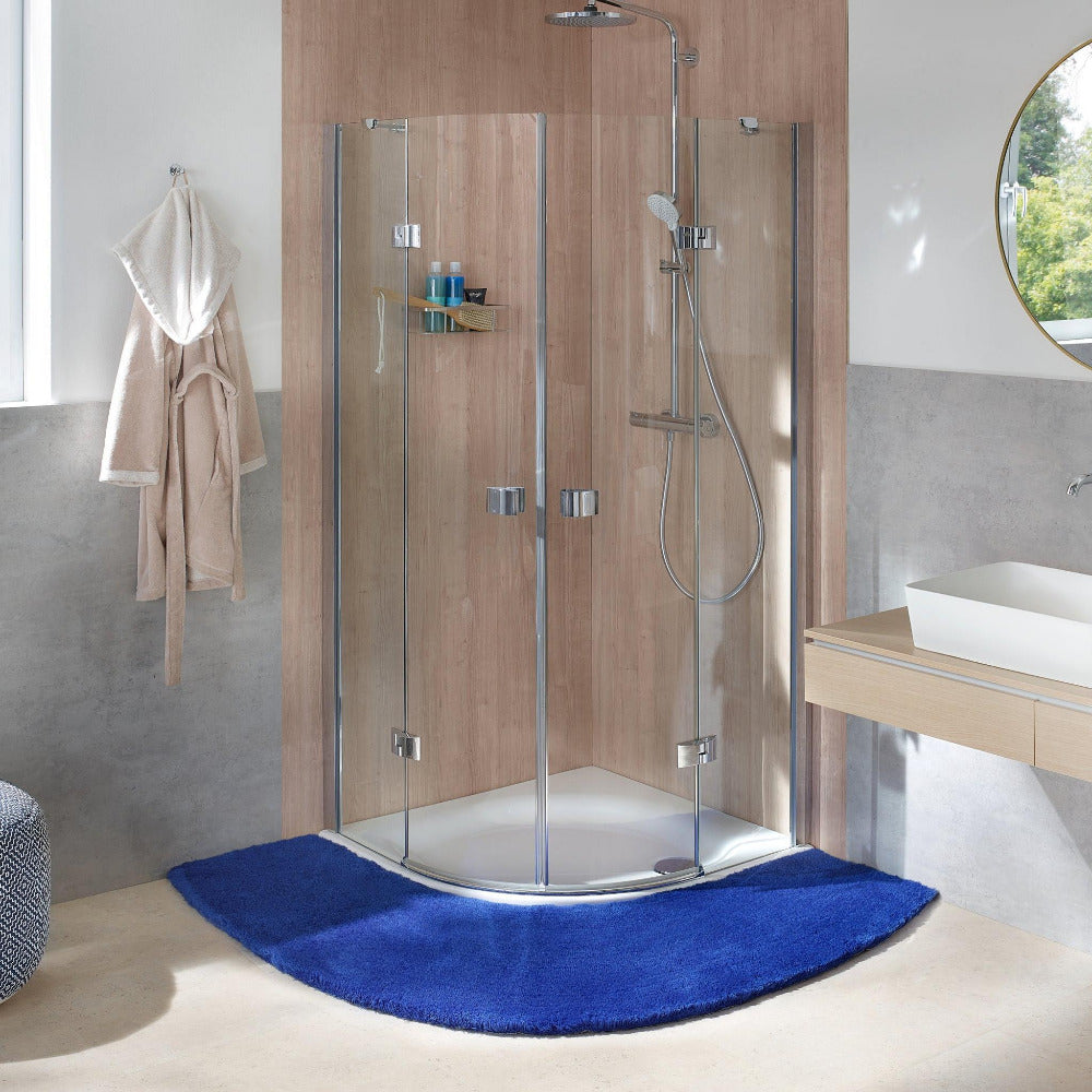 Eckdusche mit Glaswänden, Regendusche und blauem halbrundem Badteppich