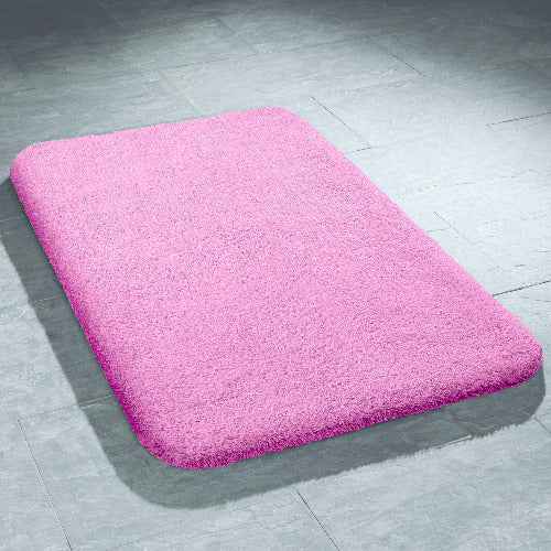Rechteckige rosa Badematte mit weichem, flauschigem Flor auf Fliesenboden