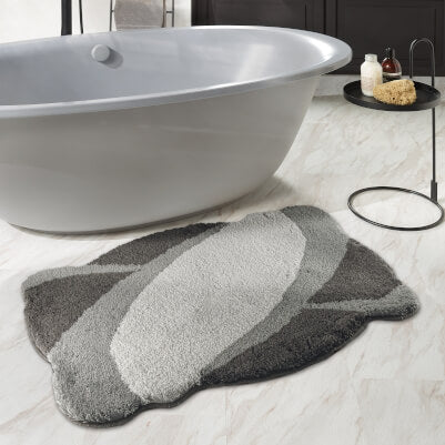 Graue Badewanne mit abstraktem grauen Badteppich im modernen Bad.