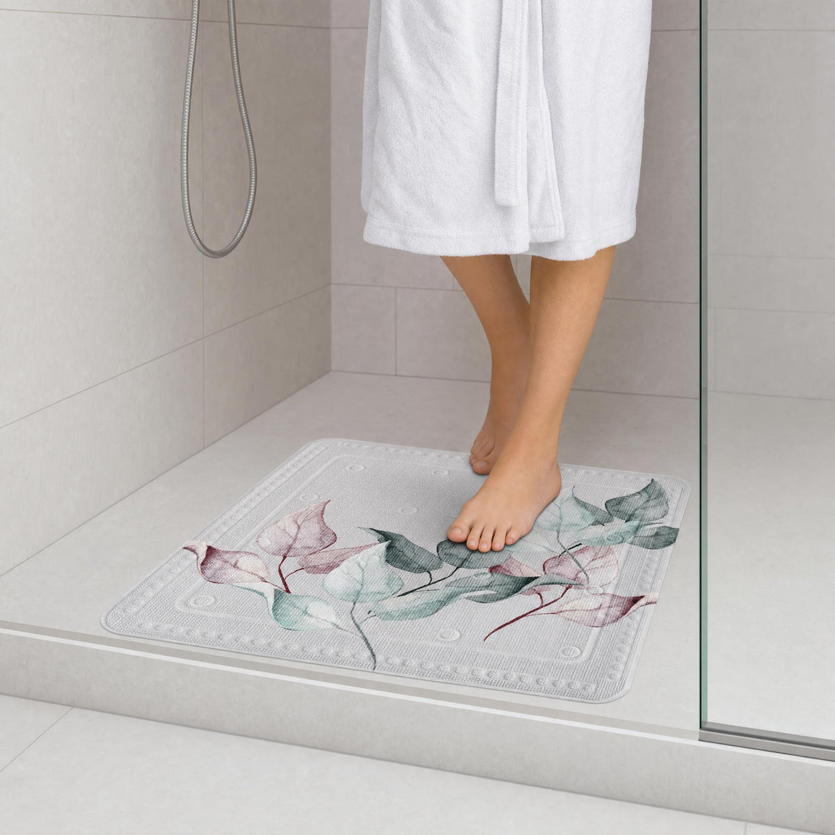 Person im Bademantel steht auf einer  Antirutschmatte mit floralem Muster.