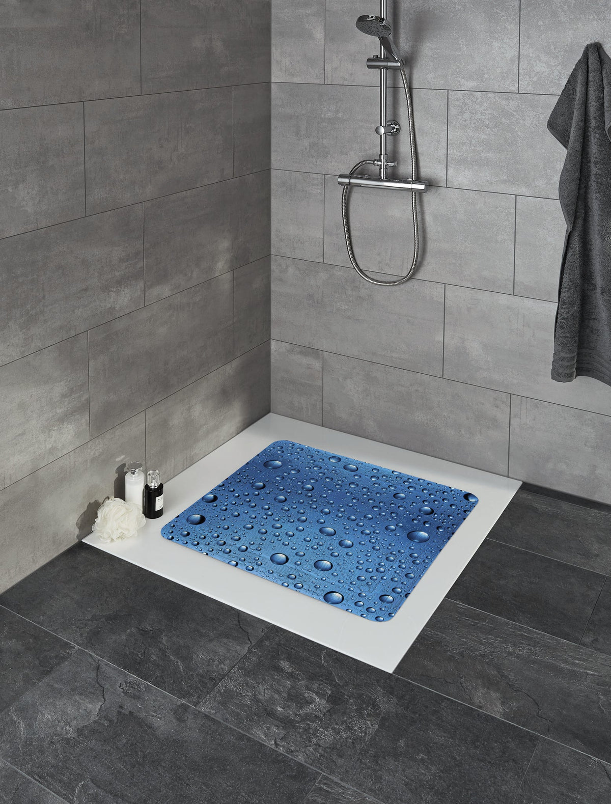 Blaue Duschmatte mit Wassertropfen in moderner gefliester Dusche Ecke