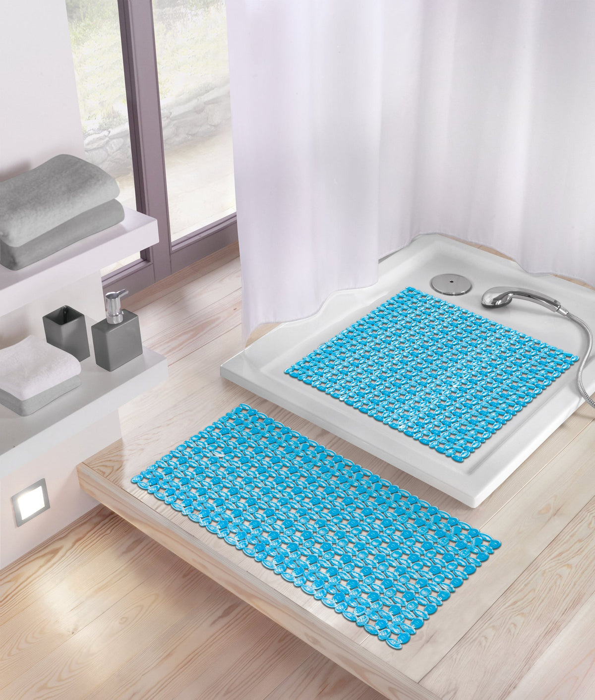 Blaue rutschfeste Duschmatten in Dusche und davor auf Holzfußboden