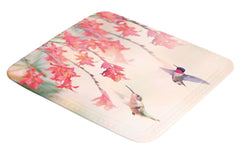 Badematte mit Kolibris und orangefarbenen Blüten auf hellem Grund