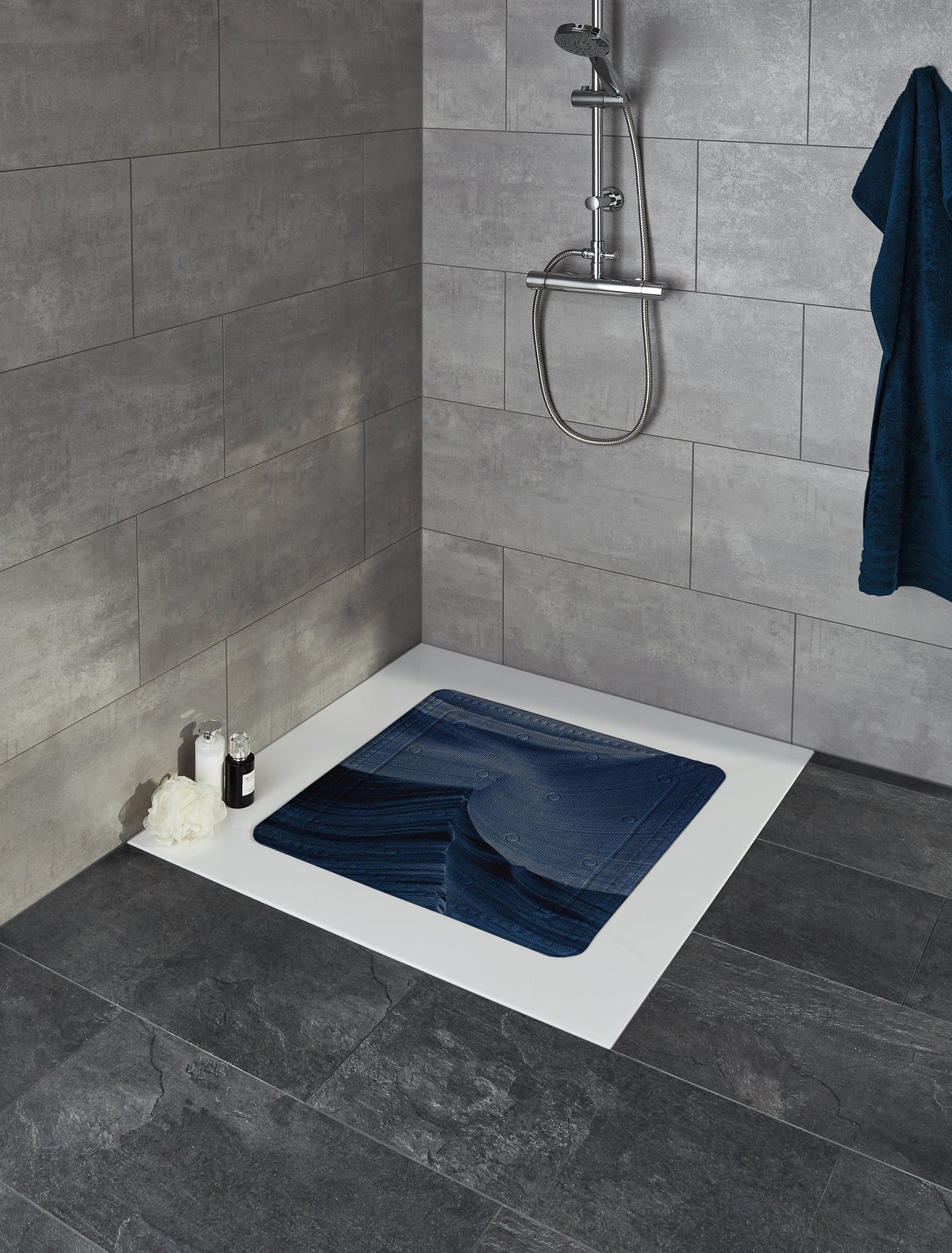 Bodengleiche Dusche mit blauer Antirutschmatte und grauen Fliesen