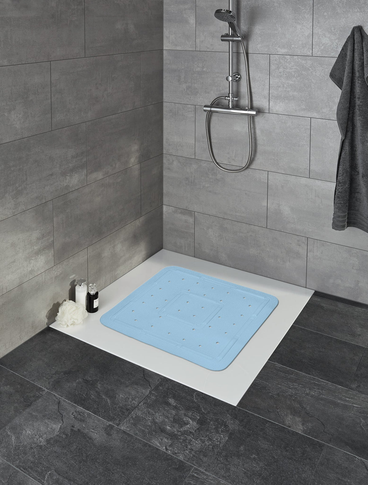 Blaue Anti-Rutsch-Badematte auf weißer Dusche mit grauen Fliesen