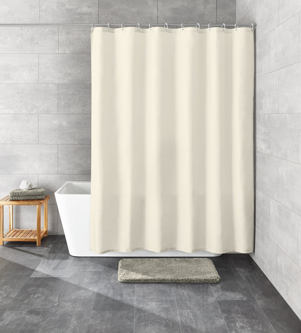 Beiger Duschvorhang vor Badewanne in grauem Badezimmer mit Teppich