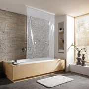 Modernes Bad mit Badewanne und perlgrauem Duschrollo vor Steinwand.