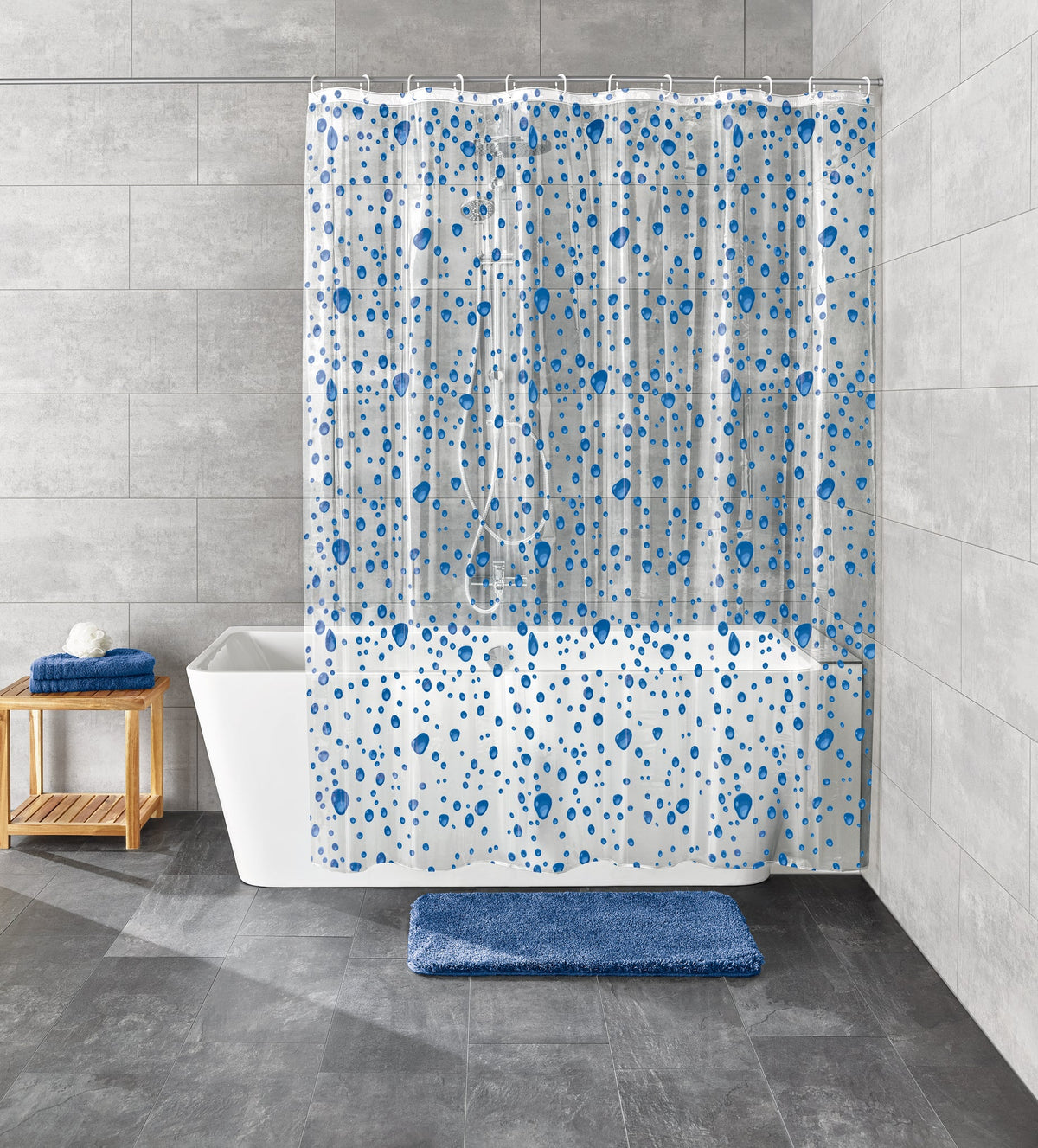 Weiße Badewanne mit blauem Duschvorhang und großen grauen Fliesenwänden