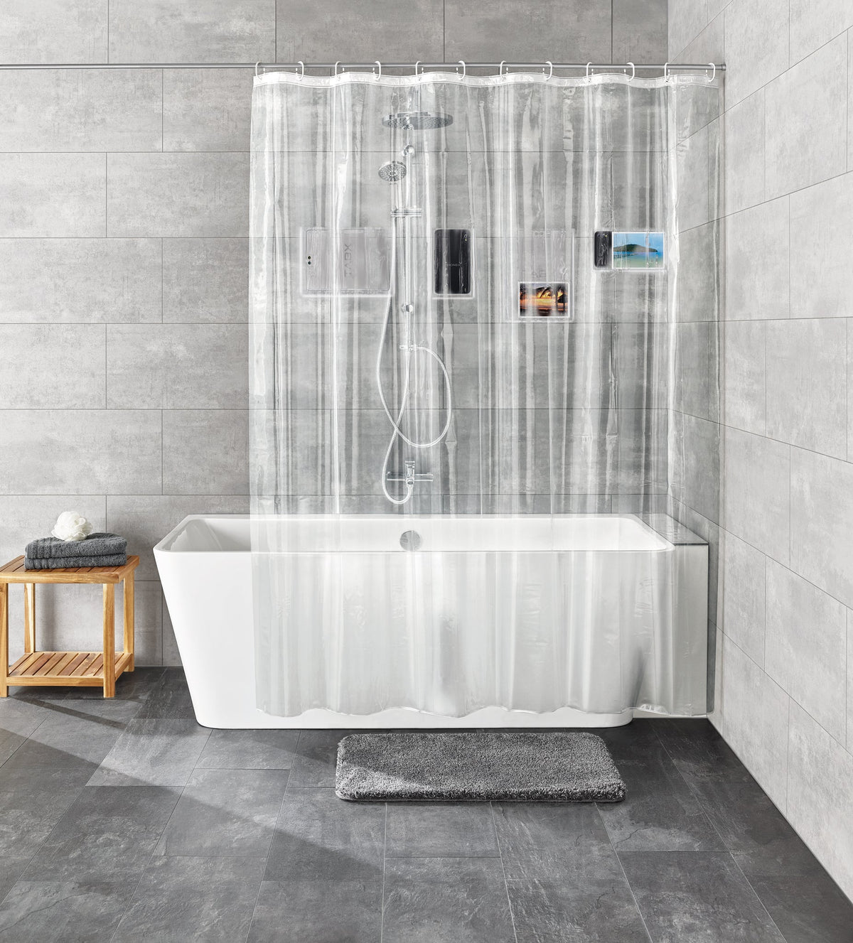 Weiße Badewanne mit Duschvorhang, Duschset, Wandfliesen und Badematte