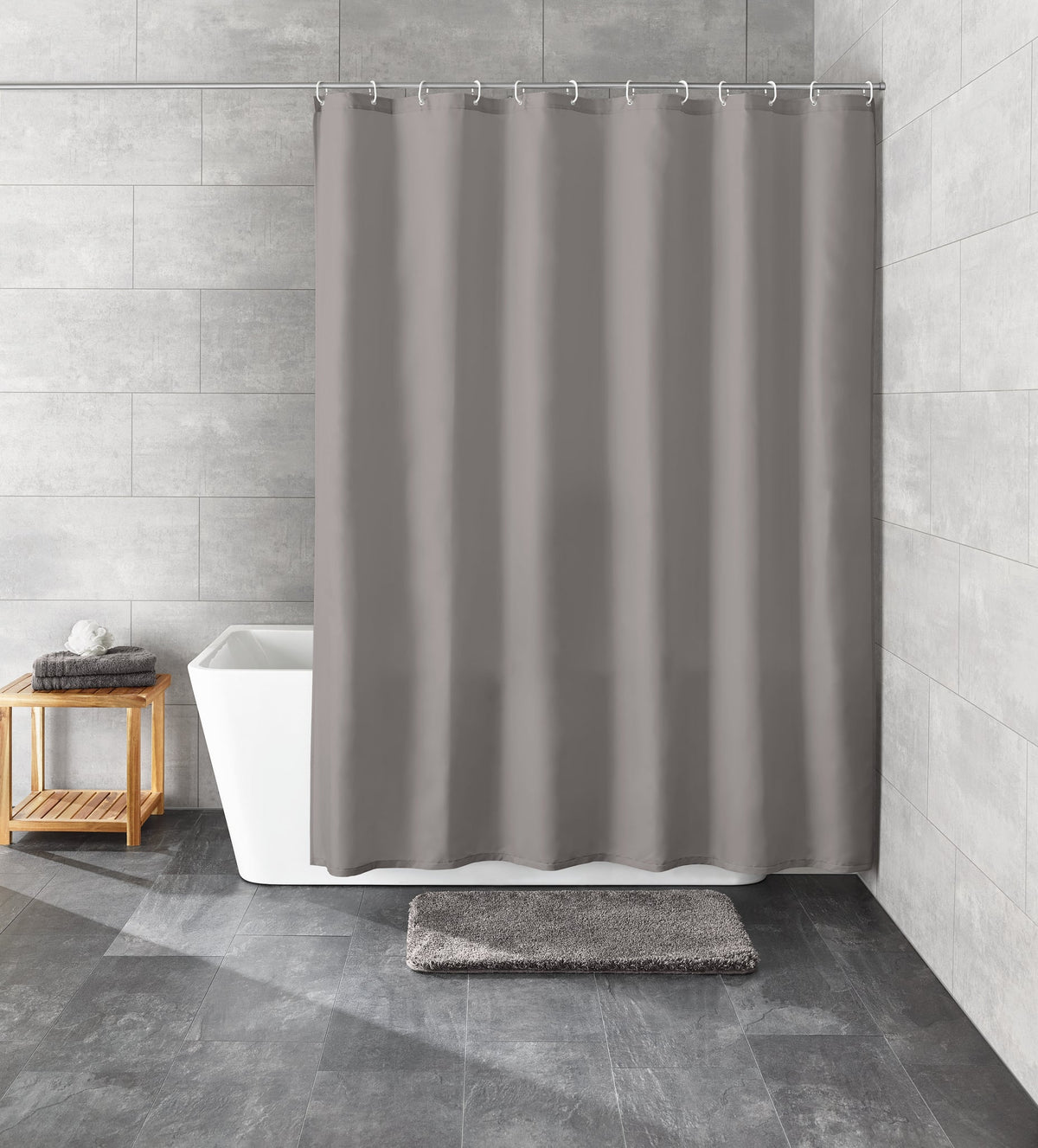 Grauer Duschvorhang vor weißer Badewanne in modernem Bad mit Matte
