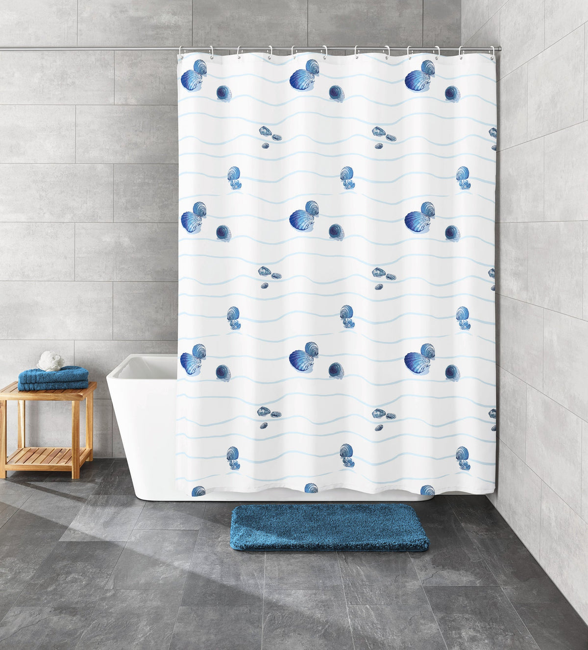 Weißer Duschvorhang mit blauen Muscheln neben Badewanne und Matte