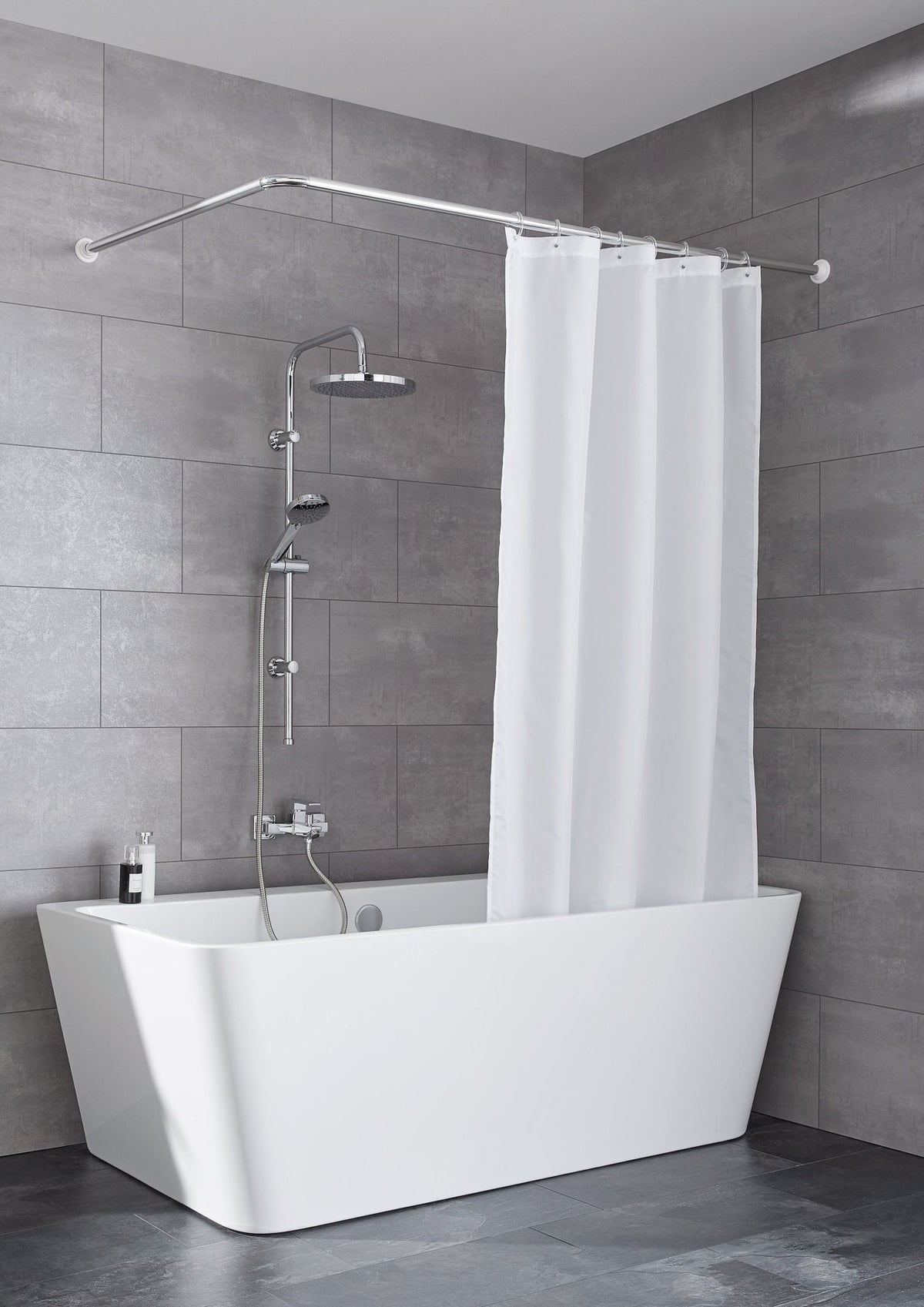 Weiße Badewanne mit Duschset, weißem Vorhang und grauer Wand dahinter