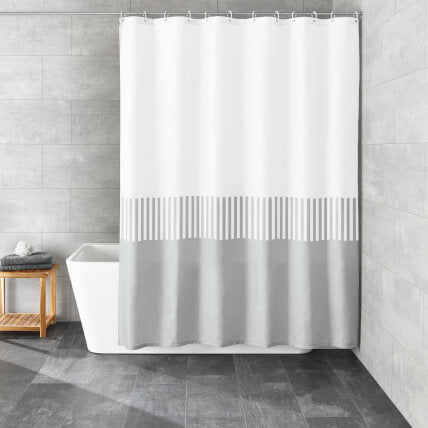Weiß-grauer Duschvorhang mit Streifenmuster vor Badewanne im Bad.