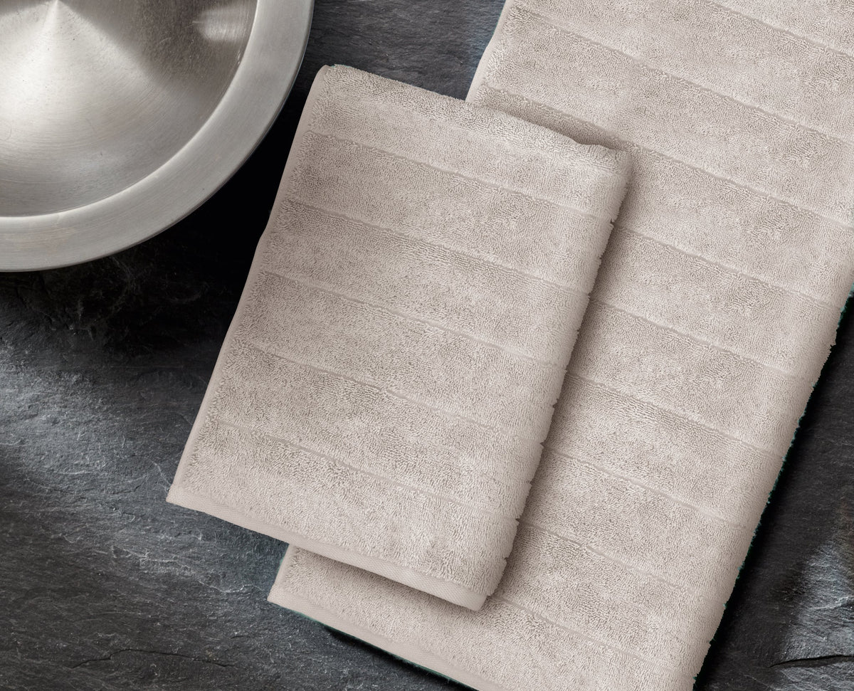 Zwei beige gestreifte Handtücher auf dunkler Steinoberfläche