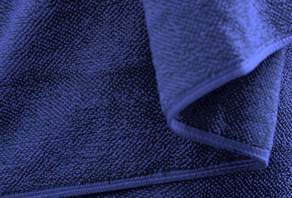 Nahaufnahme eines dunkelblauen Handtuchs mit leicht umgeschlagener Ecke