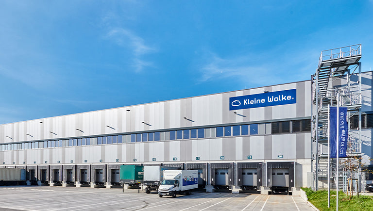 Modernes Logistikzentrum von Kleine Wolke mit Laderampen und Lkw
