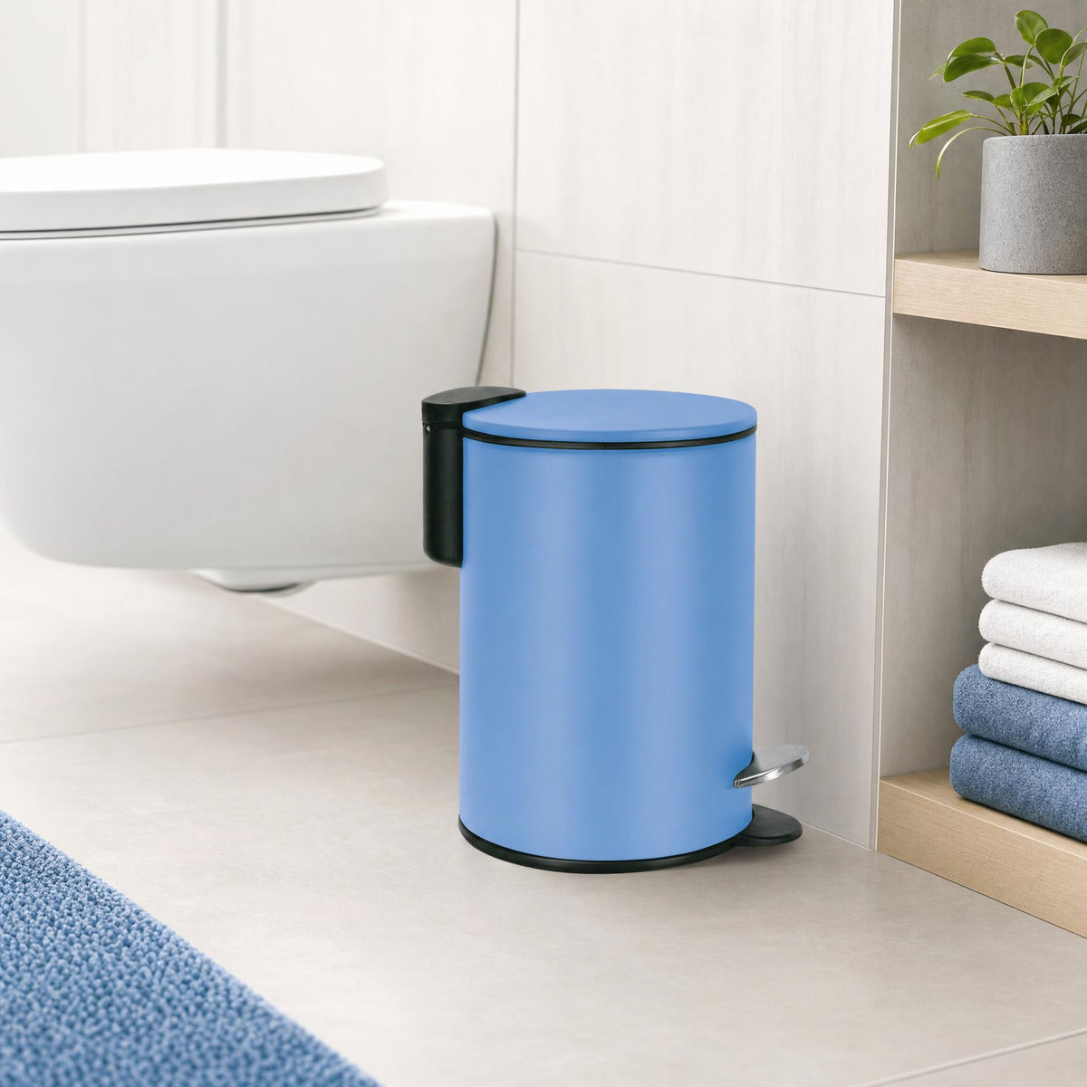 Blauer Treteimer im Bad neben WC, Regal mit Handtüchern und Pflanze.