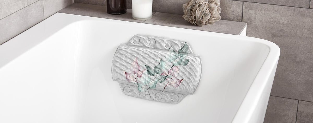 Weiße Badewanne mit floralem Nackenpolster.
